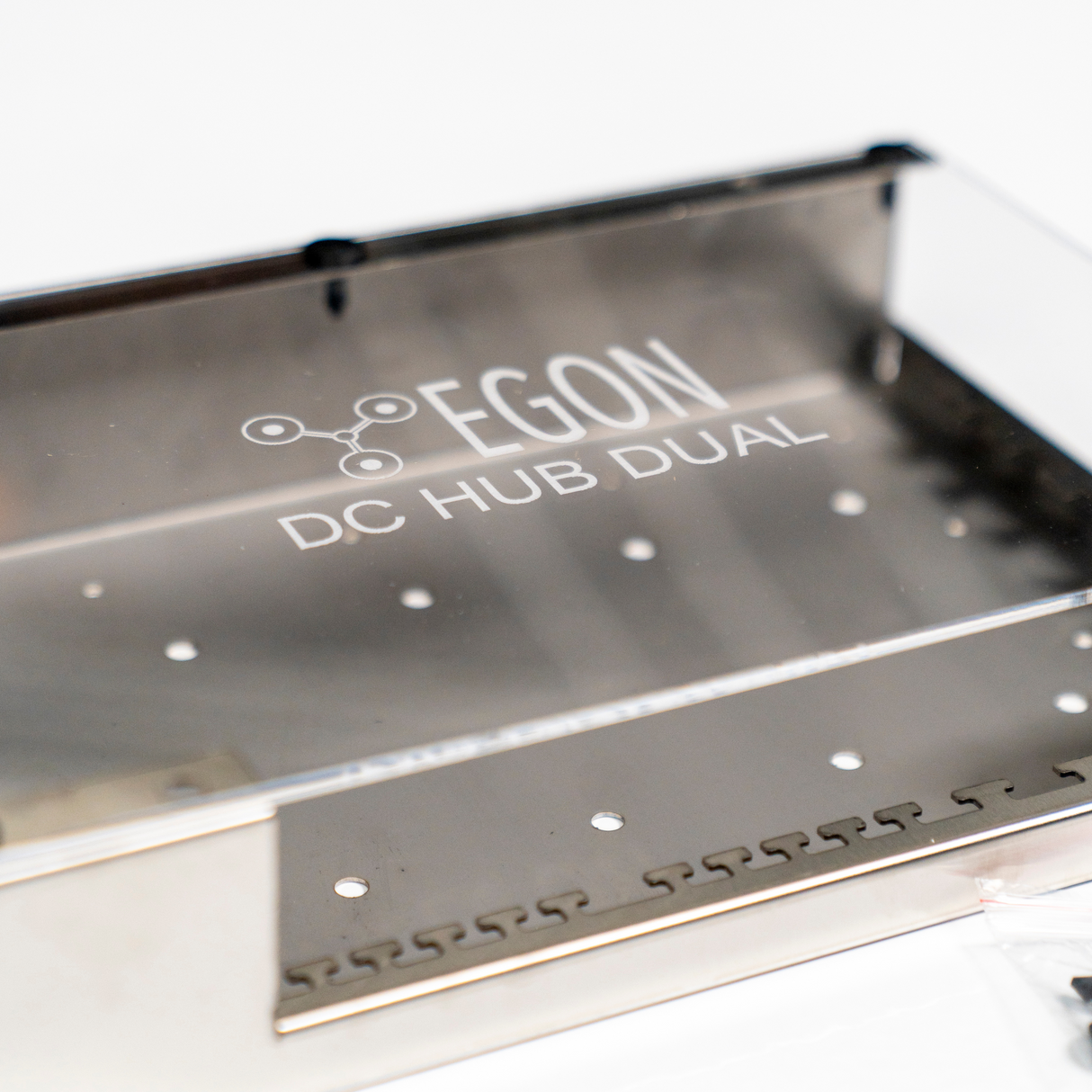 Metallic device with 'EGON' branding on a white background